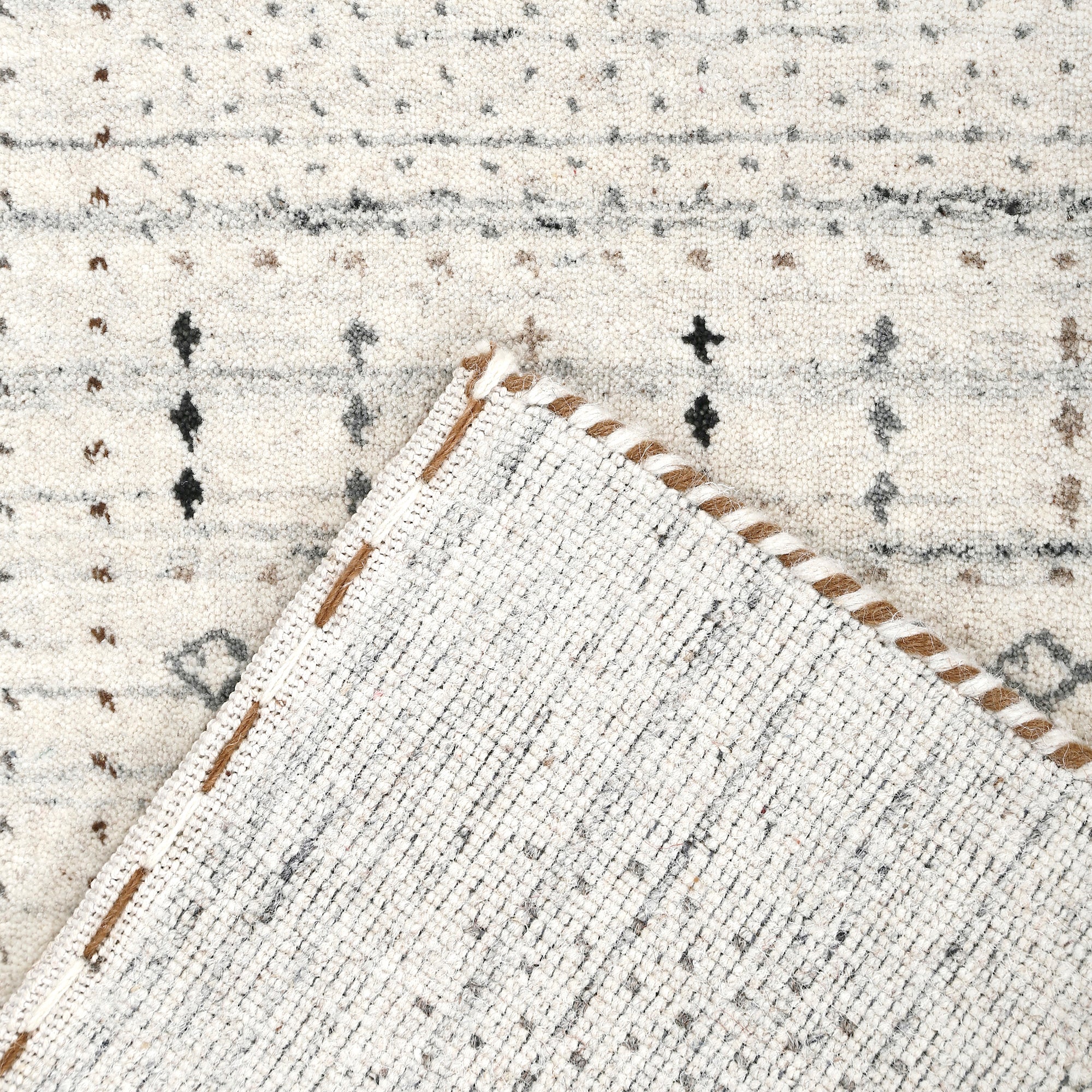 Corner and edge detail of ivory Hand Woven Loom Lori wool rug showing subtle geometric border and handcrafted finishing