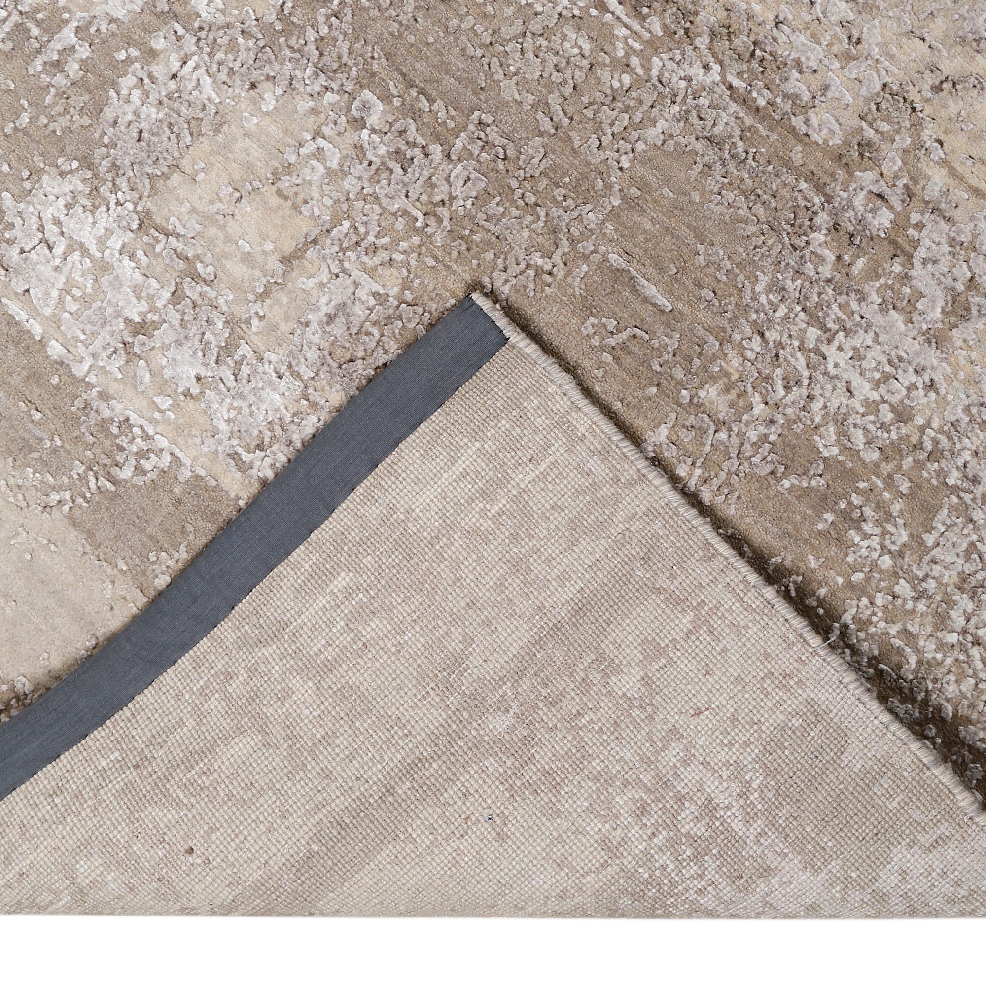 Hand-finished edge and softly distressed neutral surface of the Ivory Haze hand knotted modern rug