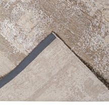Hand-finished edge and softly distressed neutral surface of the Ivory Haze hand knotted modern rug