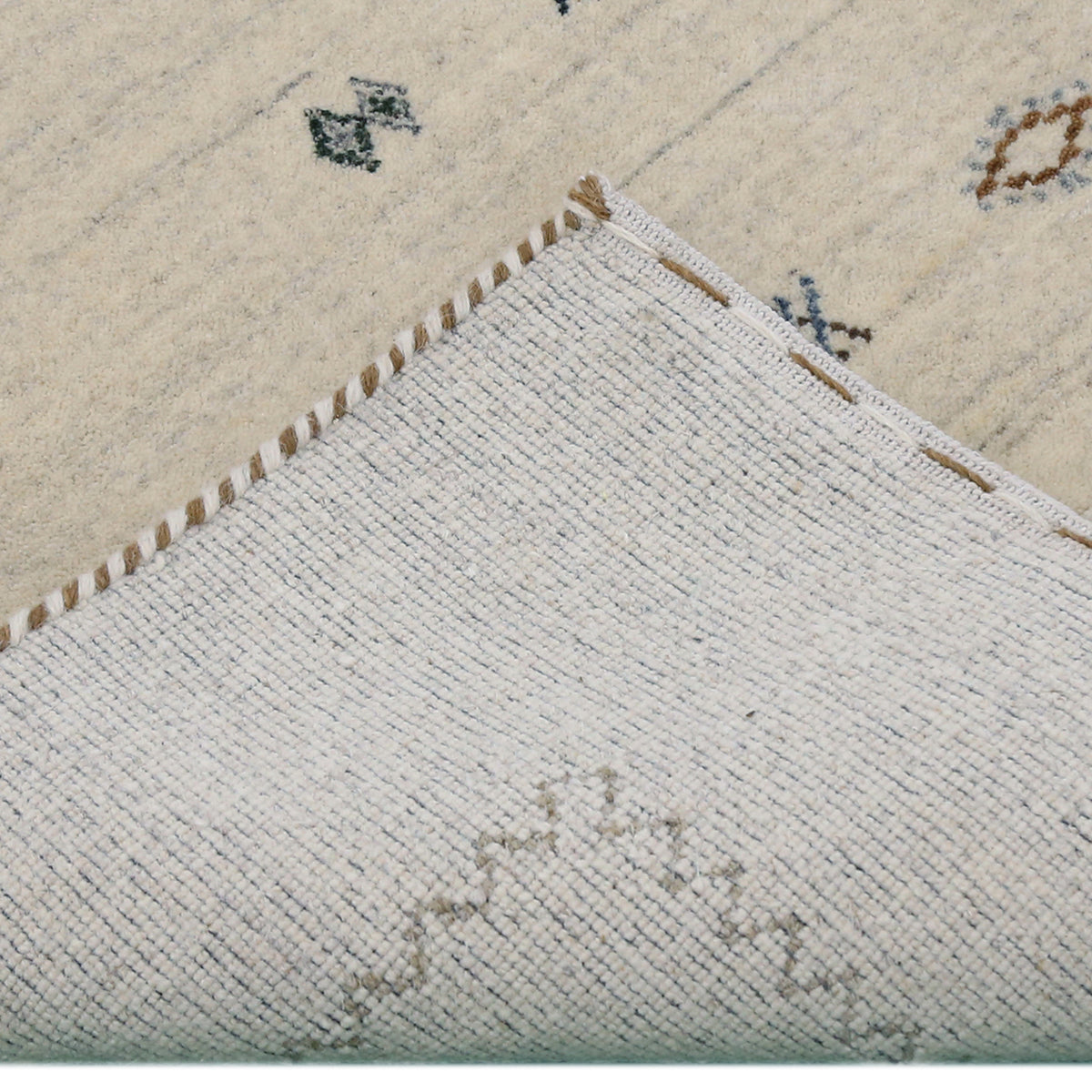 Corner and edge detail of ivory Loom Lori wool rug showing fine grey zigzag border and traditional handcrafted finishing