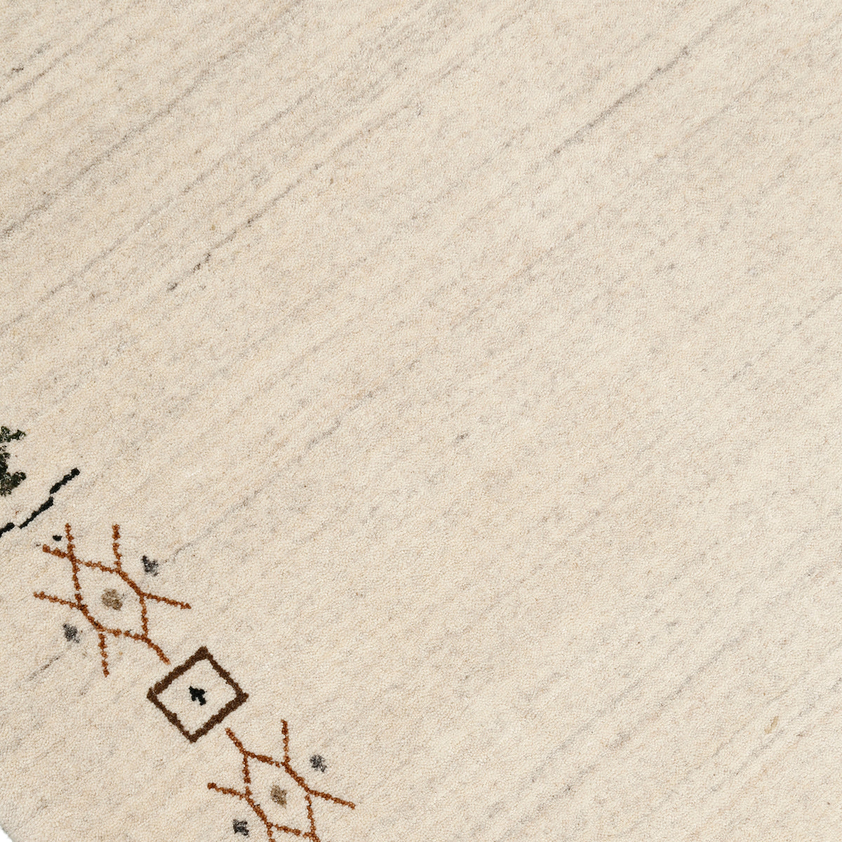 Close-up of ivory Hand Woven Loom Lori wool rug showing natural wool texture and detailed earthy tribal motifs
