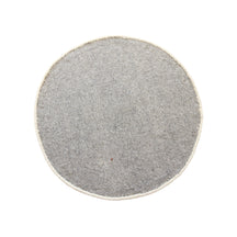 Side angle view of ivory smiley face wool kids rug showing its round shape, 12-15 mm hand tufted pile and playful cartoon design.
