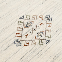Close-up of ivory cream Hand Woven Loom Lori wool rug showing natural wool texture, grey striations and tribal geometric motifs