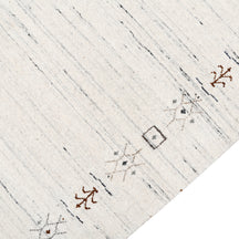 Close-up of ivory Hand Woven Loom Lori wool rug showing natural wool texture, grey linear striations and earthy tribal motifs