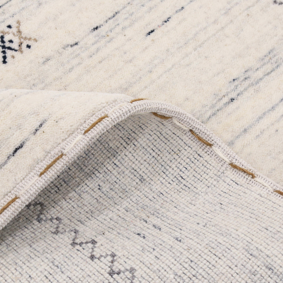 Close-up of ivory Hand Woven Loom Lori wool rug showing natural wool texture, linear detailing and fine tribal motifs