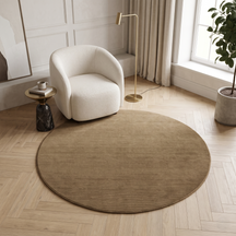 Light Beige Round Hand Woven Loom Lori wool rug styled in a modern sitting area with a cream chair, wooden flooring and natural daylight.