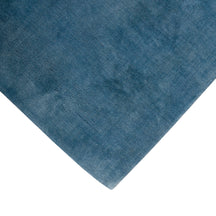 Corner and edge detail of light blue hand woven Loom Lori wool rug showing its neat finishing, soft texture and plush 12-15 mm pile.
