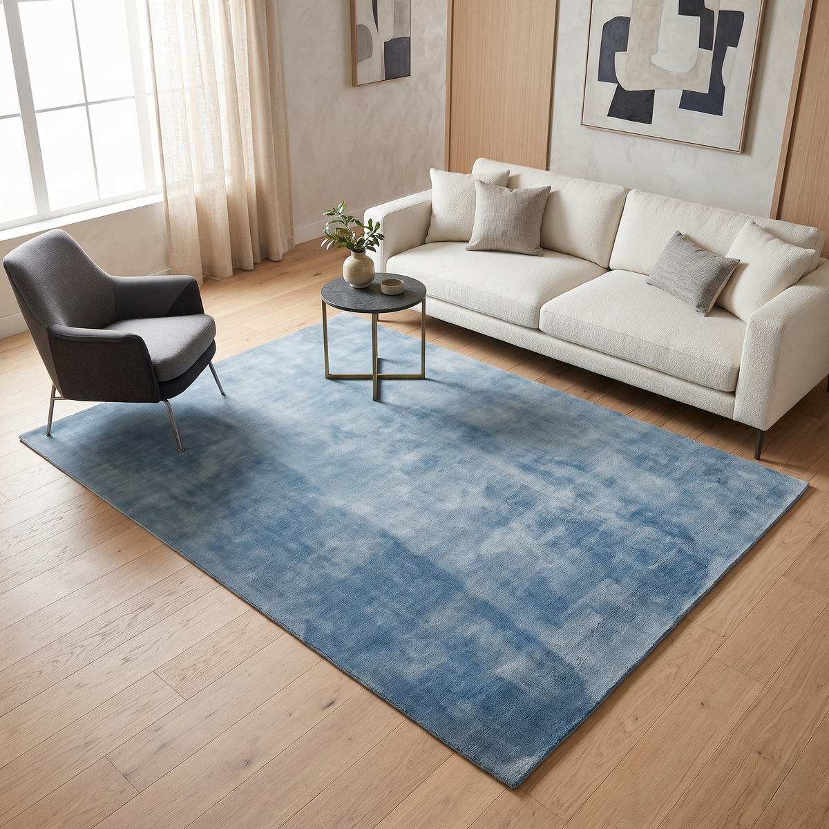 Light blue hand woven Loom Lori wool rug styled in a modern living room with neutral seating, wooden flooring and a glass coffee table.