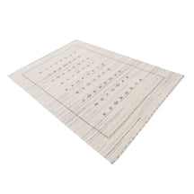 Side angle view of ivory Hand Woven Loom Lori wool rug highlighting soft texture and understated tribal design