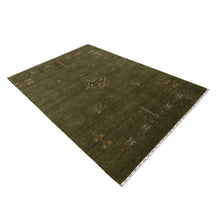 Side perspective of olive green Hand Woven Loom Lori wool rug highlighting handcrafted wool texture and central tribal medallion design