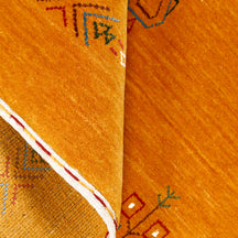 Close-up of golden ochre Hand Woven Loom Lori wool rug showing natural wool texture, central diamond detailing and folk motifs