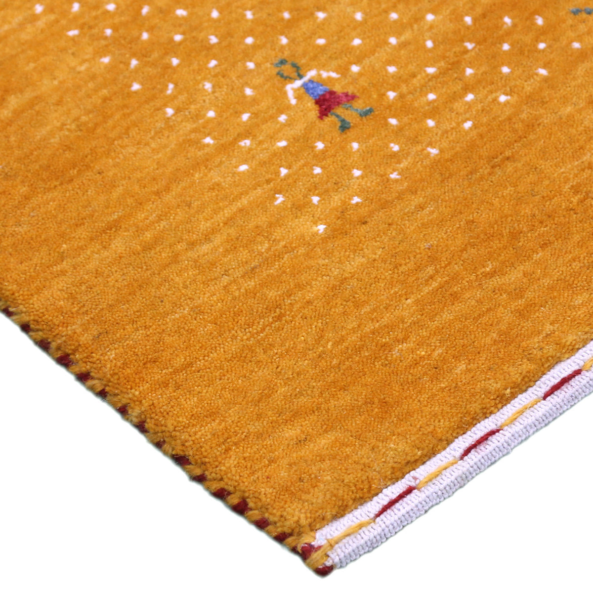 Corner and edge detail of golden mustard Loom Lori wool rug showing ivory dotted sections, folk motifs and handcrafted finishing