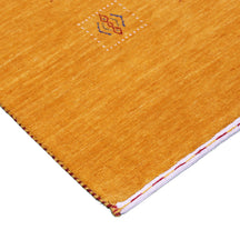 Corner and edge detail of golden mustard Hand Woven Loom Lori wool rug showing natural wool texture and handcrafted finishing