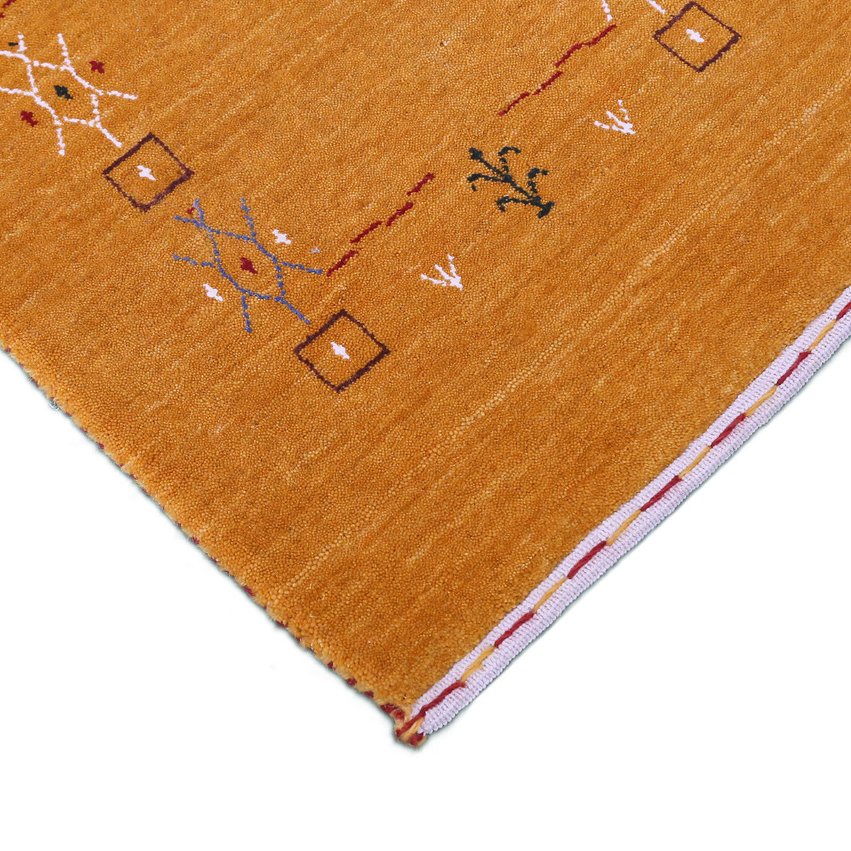 Corner and edge detail of golden mustard Loom Lori wool rug showing geometric tribal motifs and handcrafted finishing