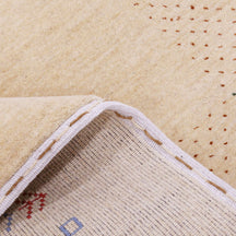 Close-up of natural beige Hand Woven Loom Lori wool rug showing natural wool texture, botanical symbols and geometric tribal motifs