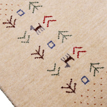 Close-up of natural beige Hand Woven Loom Lori wool rug showing natural wool texture, botanical symbols and geometric tribal motifs