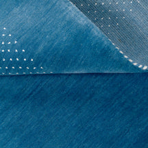 Close-up of ocean blue Hand Woven Loom Lori wool rug showing natural wool texture, animal-inspired motifs and dotted detailing