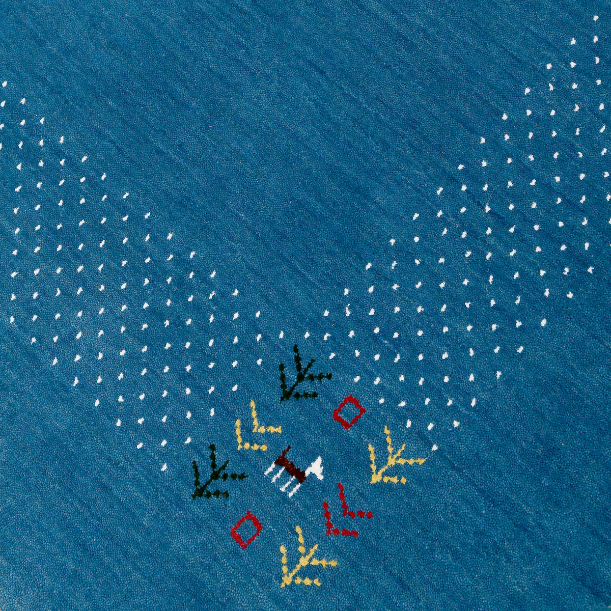 Close-up of ocean blue Hand Woven Loom Lori wool rug showing natural wool texture, animal-inspired motifs and dotted detailing
