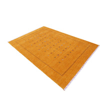 Side perspective of golden mustard Hand Woven Loom Lori wool rug highlighting natural texture, scattered motifs and zigzag border design