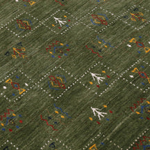 Close-up of olive green Hand Woven Loom Lori wool rug showing natural texture, framed geometric motifs and colourful tribal symbols
