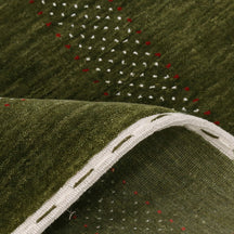 Close-up texture of Hand Woven Loom Lori wool rug showing olive green wool fibres and multicolour geometric motifs