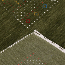 Corner and edge detail of olive green Hand Woven Loom Lori wool rug showing patterned border and handcrafted finish
