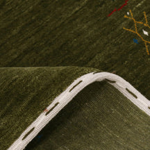 Close-up of olive green Hand Woven Loom Lori wool rug showing natural wool texture and detailed symbolic tribal motifs