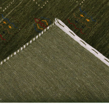 Corner and edge detail of olive green Hand Woven Loom Lori wool rug showing natural wool texture and handcrafted finishing