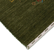 Corner and edge detail of olive green Hand Woven Loom Lori wool rug showing geometric border motifs and handcrafted finishing