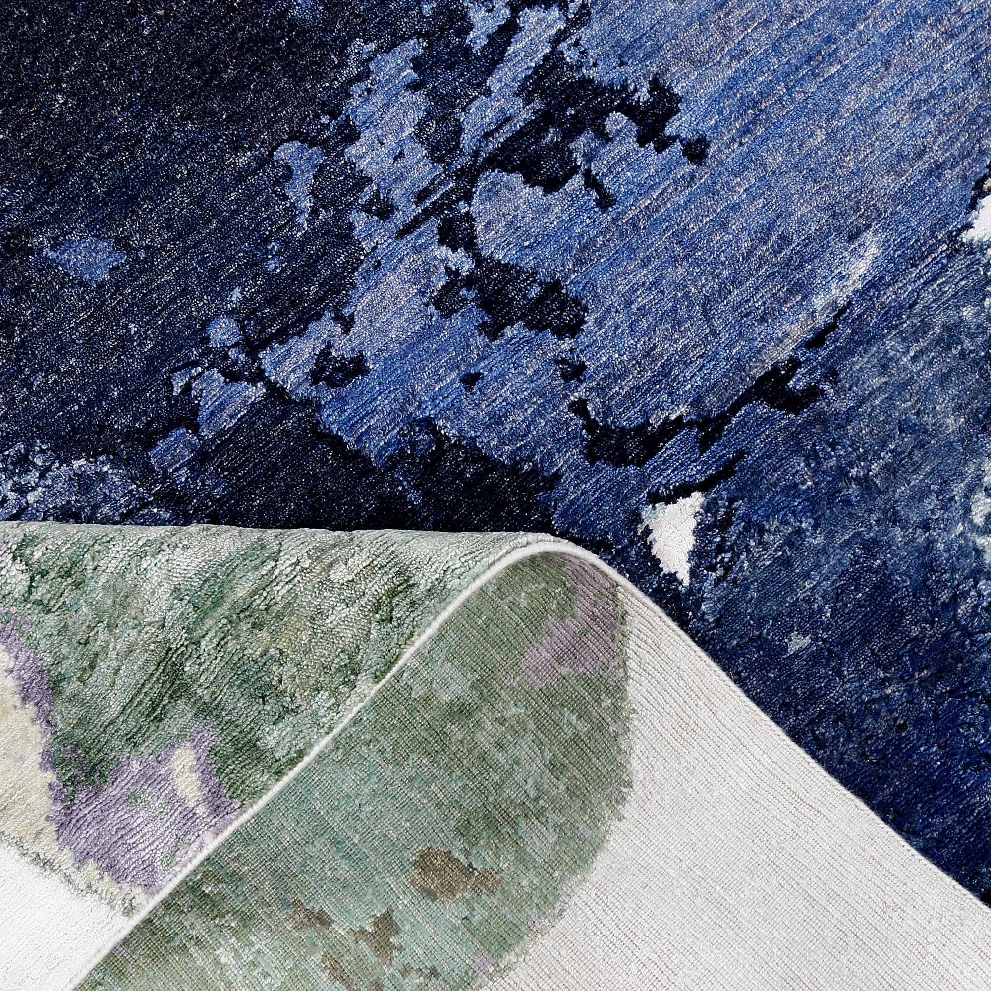 Close-up of Pastel Bloom hand knotted viscose rug with pink blue green red and navy abstract detailing