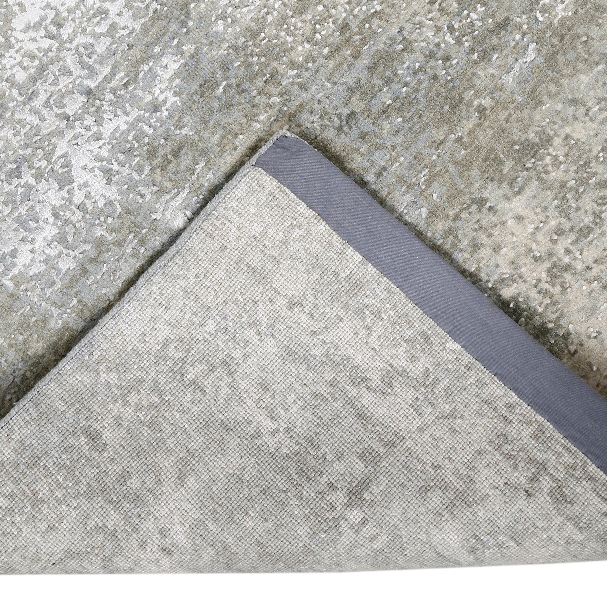 Hand-finished edge and subtle distressed detailing of the pearl mist abstract hand knotted rug