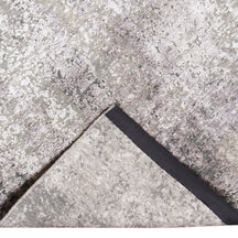Hand-finished edge and softly distressed surface of the Pearl Sand hand knotted modern rug