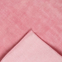 Back and edge detail of pink hand woven Loom Lori wool rug showing its woven construction, finished border and handcrafted structure.