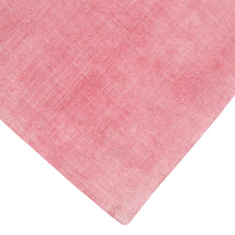 Corner and edge detail of pink hand woven Loom Lori wool rug showing its neat finishing, soft texture and plush 12-15 mm pile.