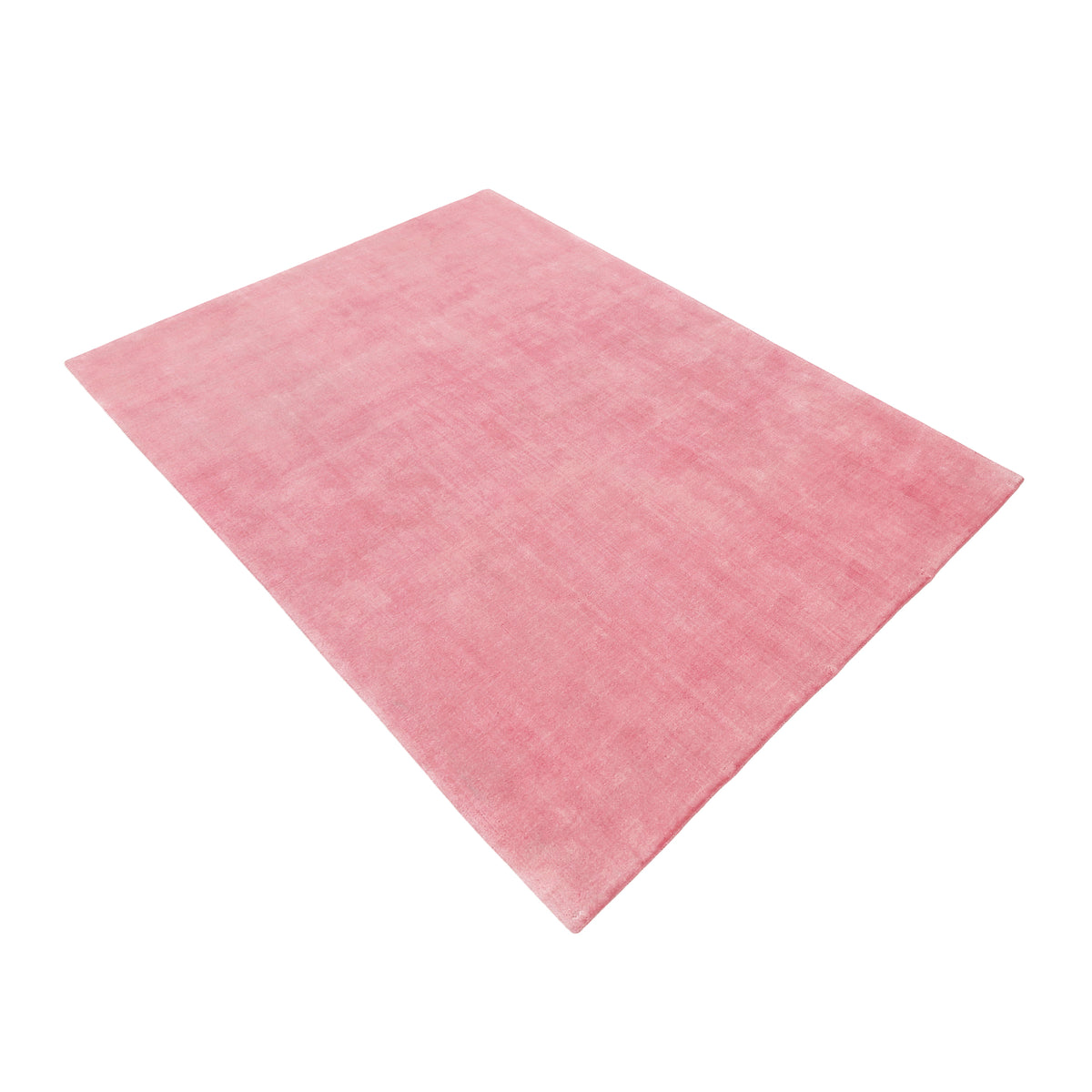 Side angle view of pink hand woven Loom Lori wool rug showing its rectangular shape, soft surface and subtle tonal texture.