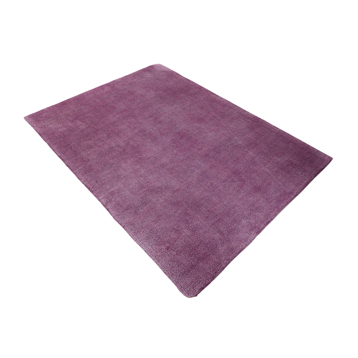 Side angle view of purple hand woven Loom Lori wool rug showing its rectangular shape, plain surface and soft tonal texture.