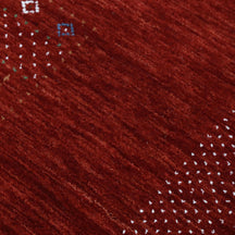 Close-up texture of red Hand Woven Loom Lori wool rug showing natural wool fibres and detailed tribal motifs