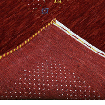 Corner and edge detail of red Hand Woven Loom Lori wool rug showing dotted border and handcrafted finishing