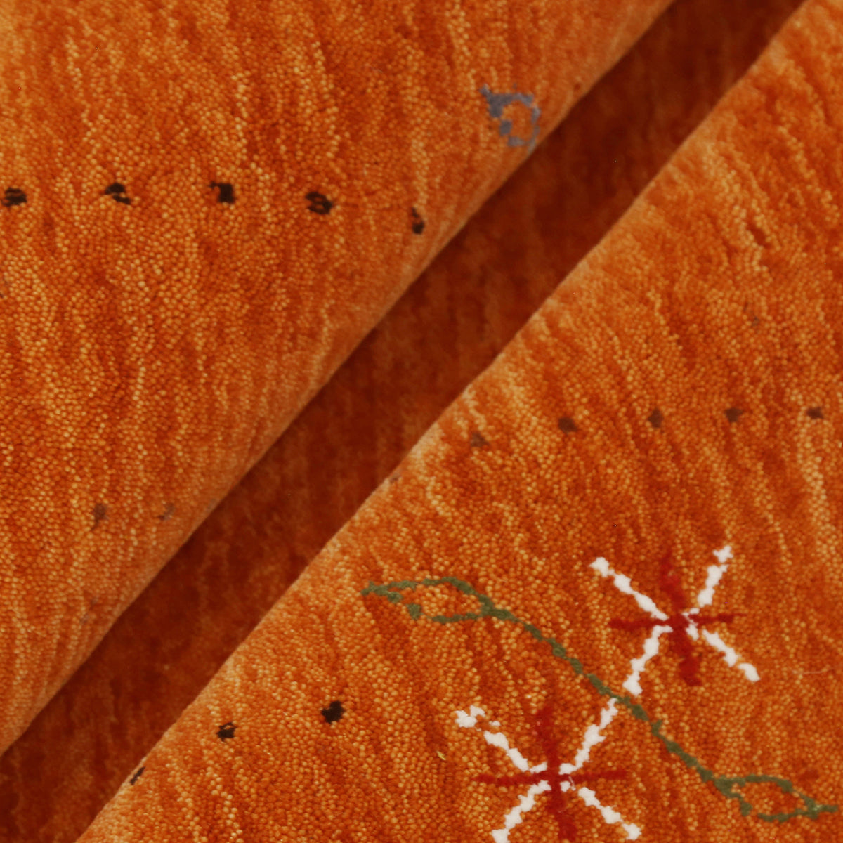 Close-up texture of rust orange Hand Woven Loom Lori wool rug showing natural wool fibres and delicate floral motif detailing