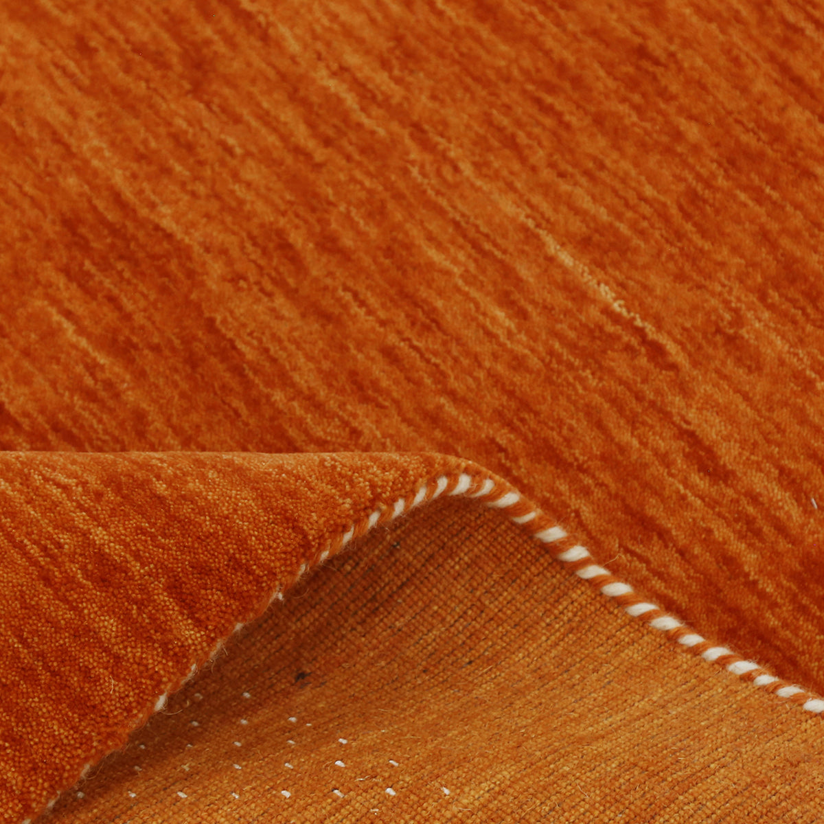 Close-up of terracotta orange Hand Woven Loom Lori wool rug showing natural wool texture, dotted detailing and multicolour tribal motifs