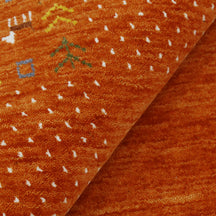Close-up of terracotta orange Hand Woven Loom Lori wool rug showing natural wool texture, dotted detailing and multicolour tribal motifs