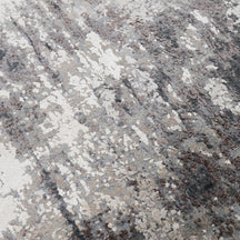 Close-up of the hand knotted wool and viscose texture with silver grey ivory and charcoal abstract detailing