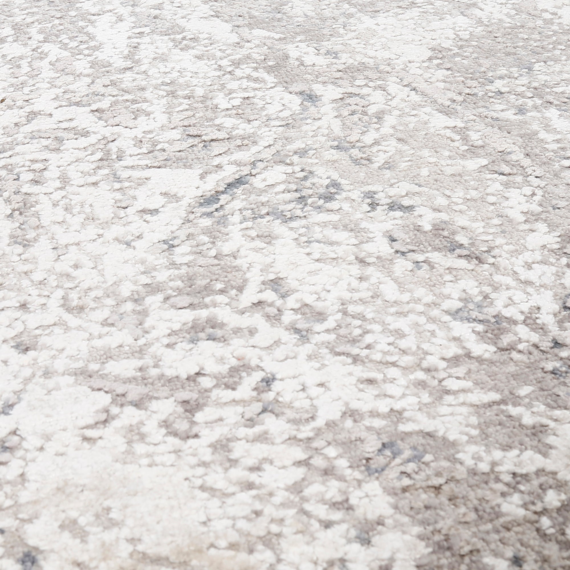 Close-up of the hand knotted wool and viscose texture with silver grey ivory beige and muted blue abstract detailing