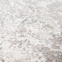 Close-up of the hand knotted wool and viscose texture with silver grey ivory beige and muted blue abstract detailing