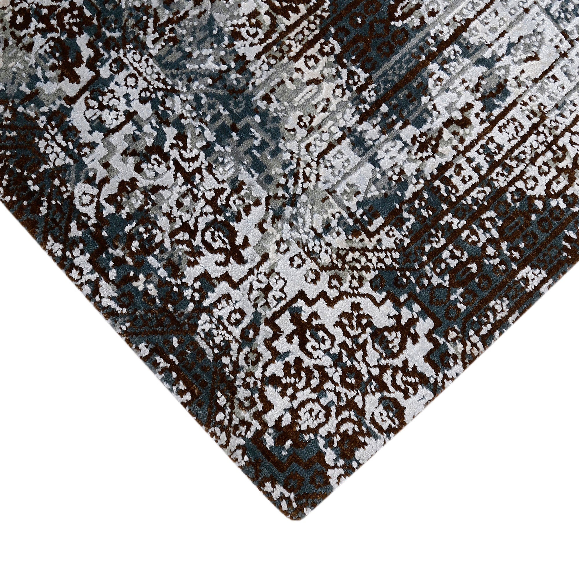 Hand-finished edge and layered distressed ornamental detailing of the silver slate hand knotted rug