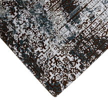Hand-finished edge and layered distressed ornamental detailing of the silver slate hand knotted rug