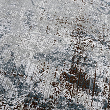 Close-up of the hand knotted wool and viscose texture with silver grey slate and distressed geometric detailing