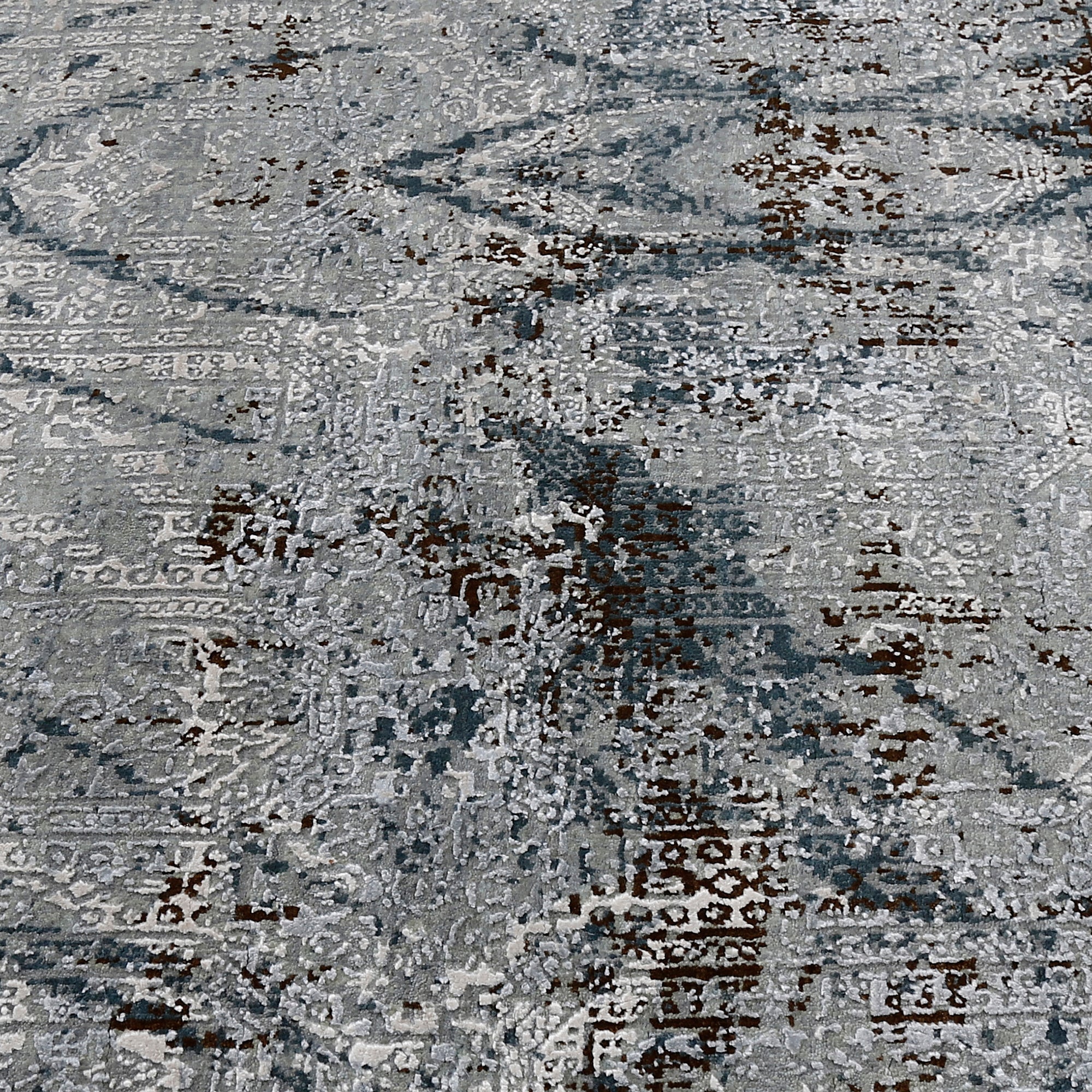 Close-up of the hand knotted wool and viscose texture with silver grey slate and distressed geometric detailing