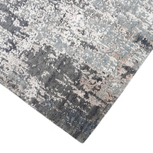 Hand-finished edge and layered distressed detailing of the silver taupe abstract hand knotted rug