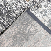 Hand-finished edge and layered distressed detailing of the silver taupe abstract hand knotted rug